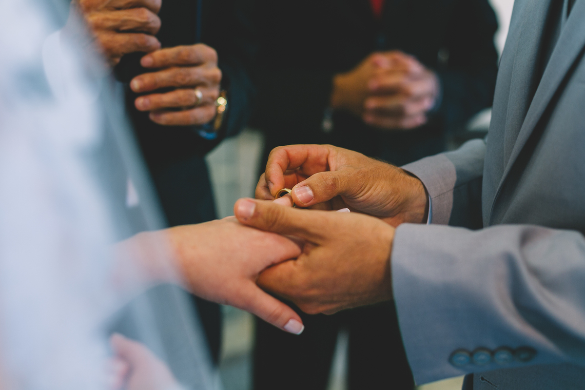 noivo colocando a aliança na mão da noiva