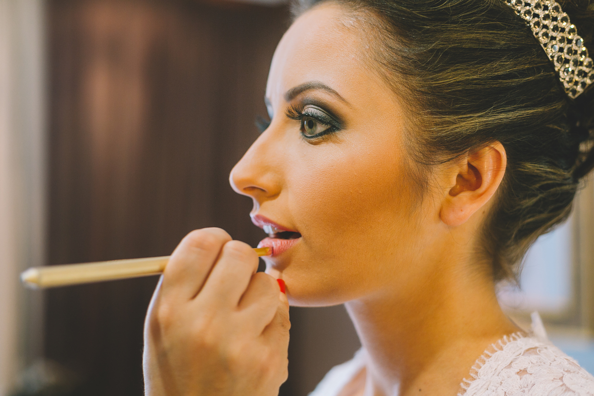 Terminando a maquiagem da noiva passando o batom