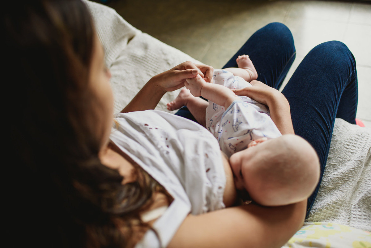 madre amamantando a su bebe y lo acaricia