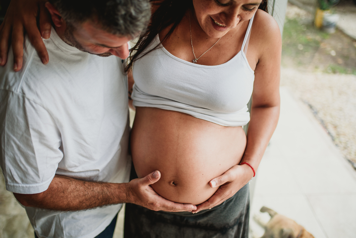 pareja se rie y toca la panza