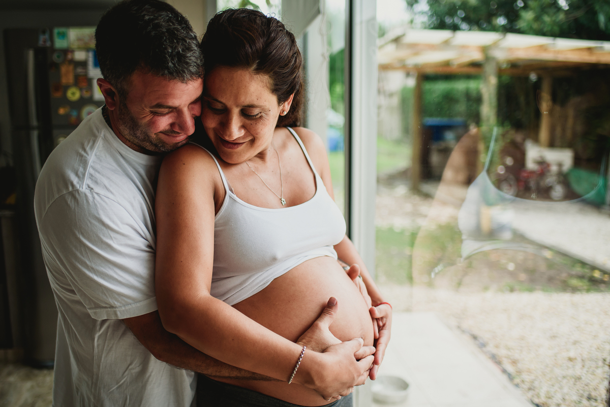 pareja se abraza la panza y rien
