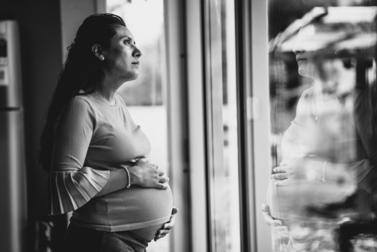 mujer embarazada mira a la ventana