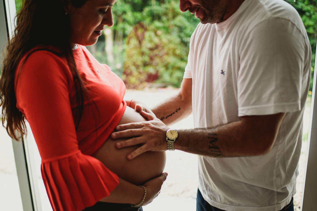 hombre y mujer miran la panza embarazada