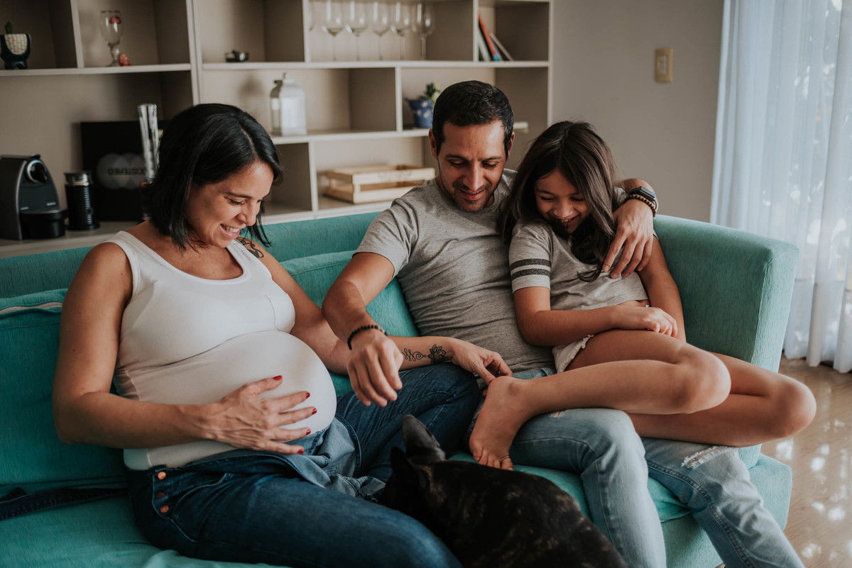 familia acaricia la panza de la mama