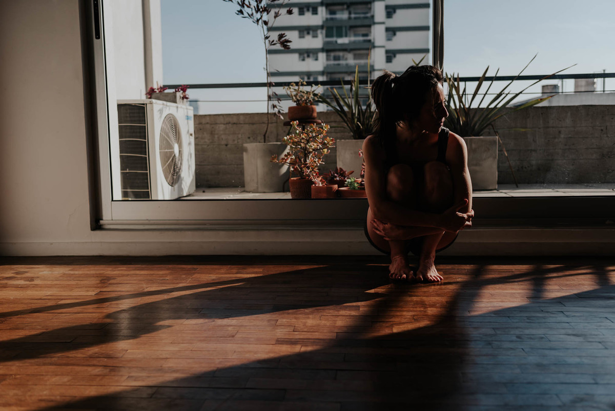 mujer agachada mira hacia el sol