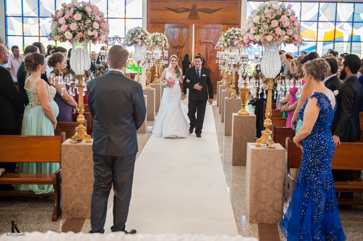 entrada da noiva casamento quedas do iguaçu noiva com vestido branco e buquet junto com o pais e o noivo ansioso aguardando na igreja fotografo katy tesser