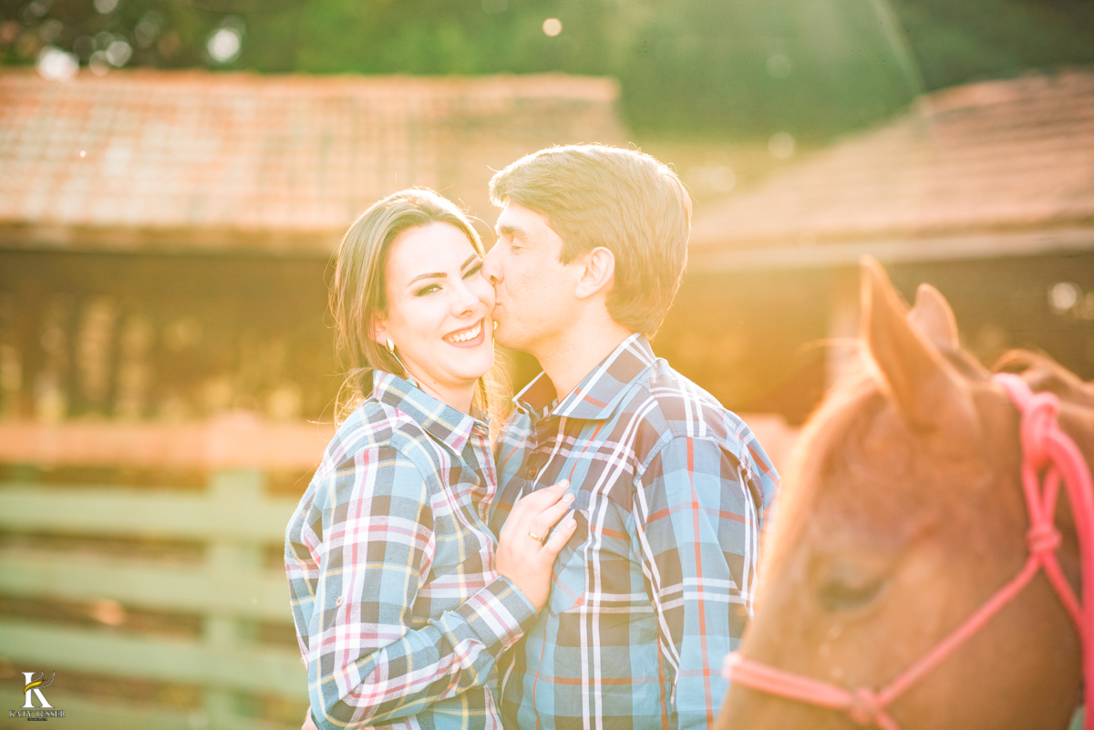 sessão pre casamento, na fazenda com cavalos e outros animais, com um casal com roupas cowntry a noiva com vestido branco, registrado pela fotografa katy tesser
