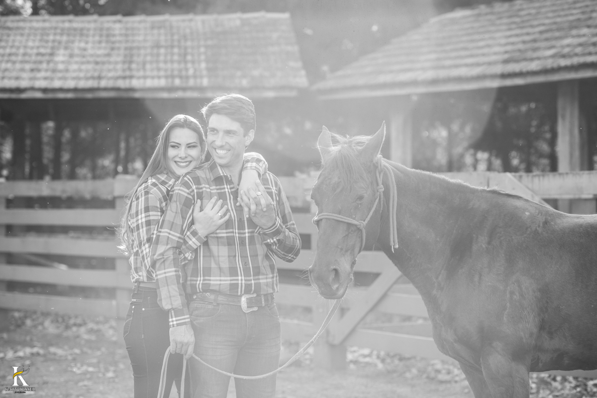 sessão pre casamento, na fazenda com cavalos e outros animais, com um casal com roupas cowntry a noiva com vestido branco, registrado pela fotografa katy tesser