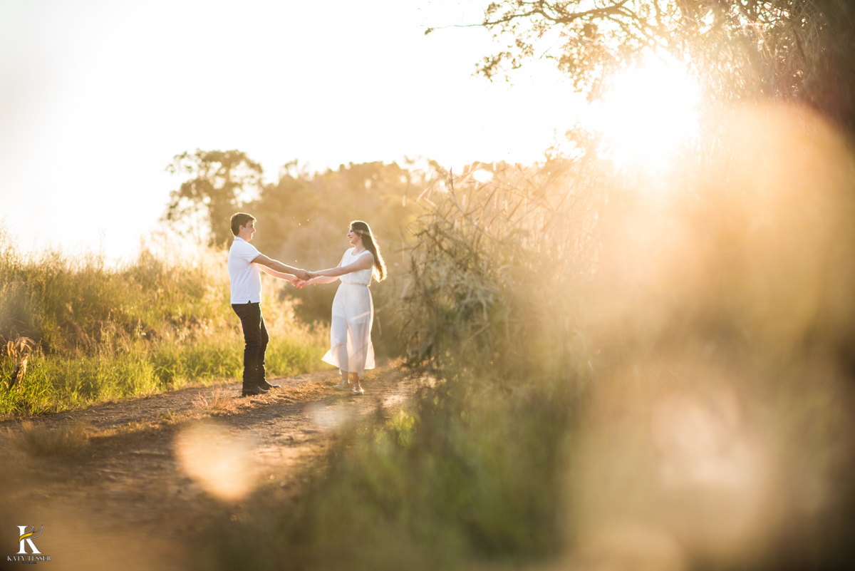 sessão pre casamento, na fazenda com cavalos e outros animais, com um casal com roupas cowntry a noiva com vestido branco, registrado pela fotografa katy tesser