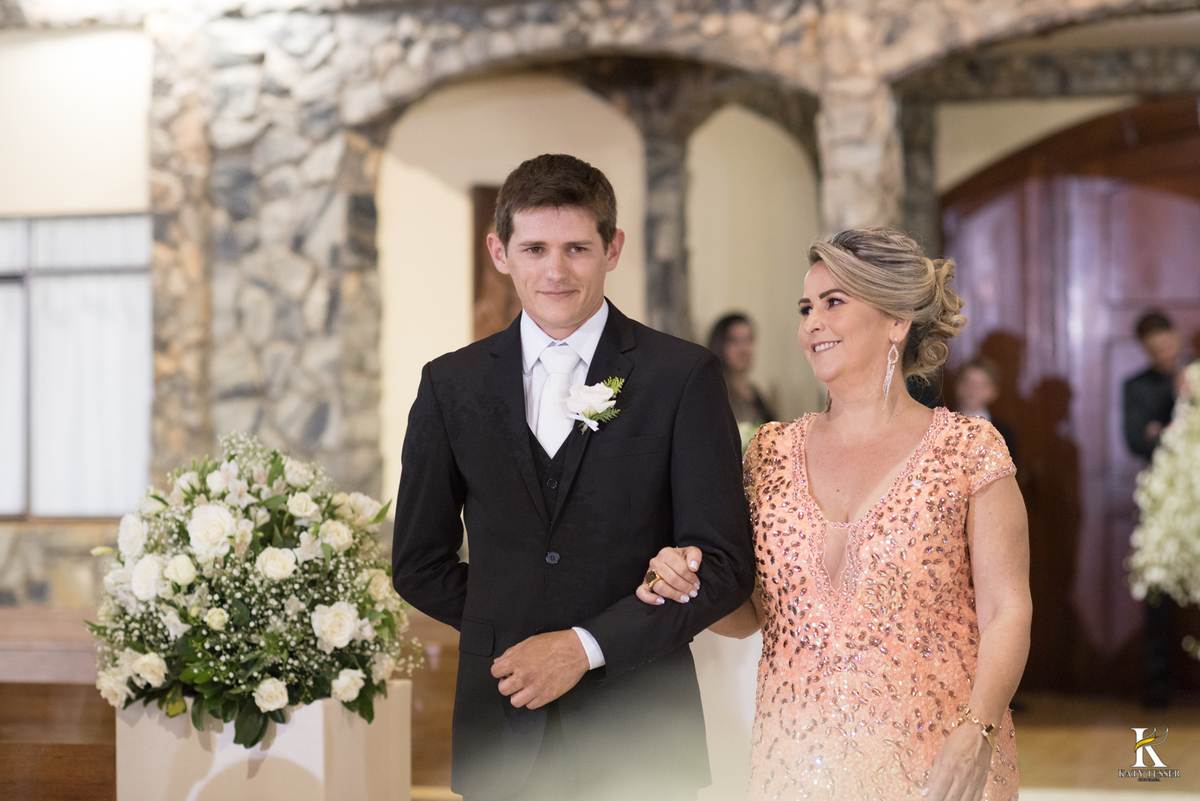 cerimonia religiosa de camila e fernando no santuario de nossa senha aparecida em laranjeiras do sul a decoração rosas brancas pajens com carrinho de bebe plaquinhas com mensagens e uma boneca com as alianças katy tesser fotografo