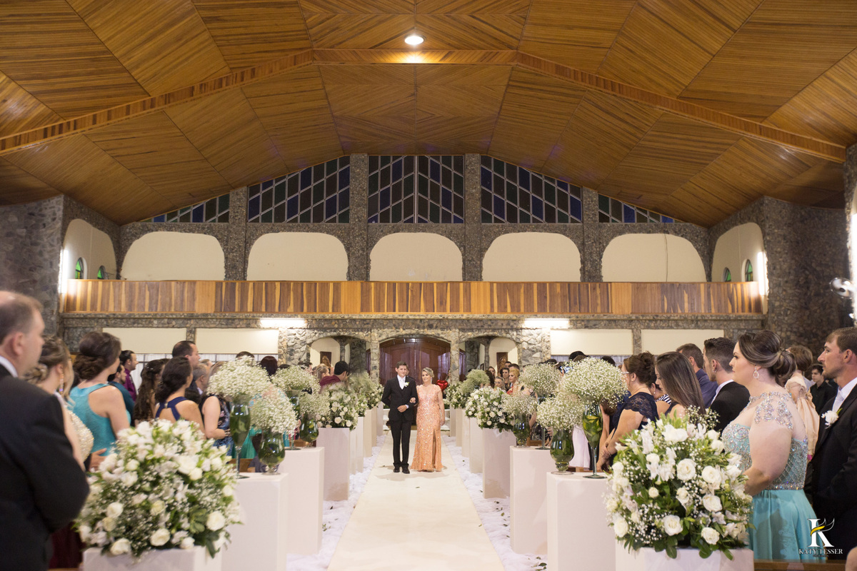 cerimonia religiosa de camila e fernando no santuario de nossa senha aparecida em laranjeiras do sul a decoração rosas brancas pajens com carrinho de bebe plaquinhas com mensagens e uma boneca com as alianças katy tesser fotografo