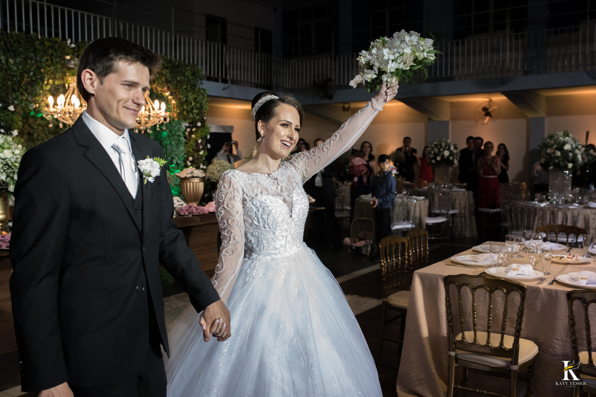 Festa do casamento de camila e fernando em laranjeiras do sul com as fotos de katy tesser fotografa com as madrinhas e padrinhos passando a gravata e o sapato e a noiva jogou o buquet para as solteiras e casadas, a valsa dos noivos
