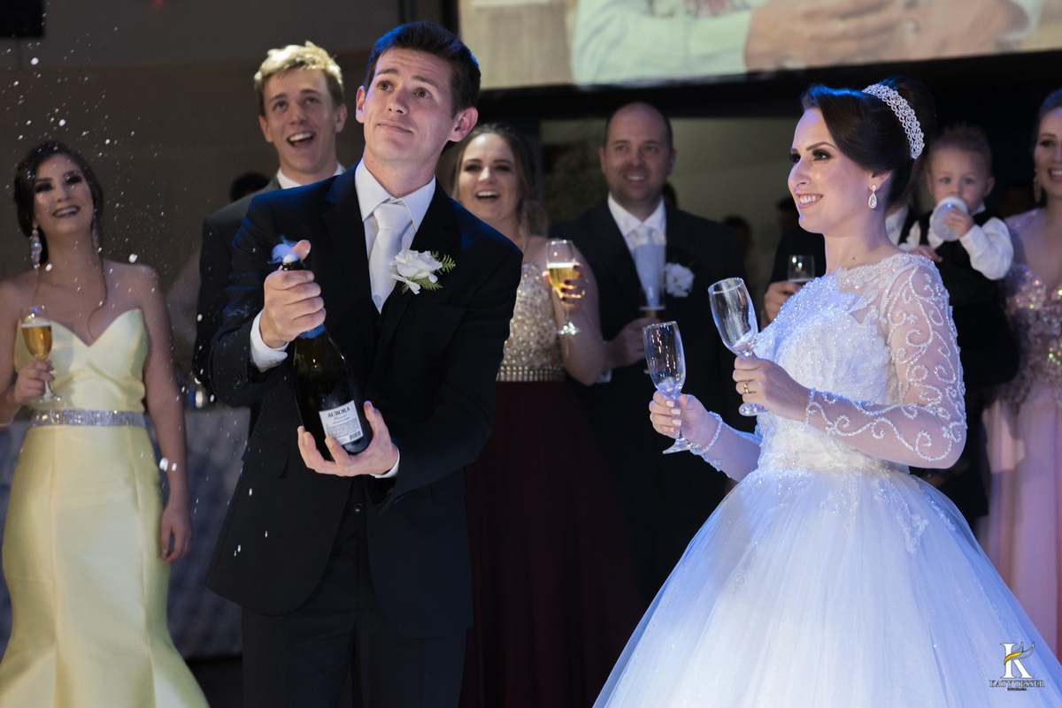 Festa do casamento de camila e fernando em laranjeiras do sul com as fotos de katy tesser fotografa com as madrinhas e padrinhos passando a gravata e o sapato e a noiva jogou o buquet para as solteiras e casadas, a valsa dos noivos