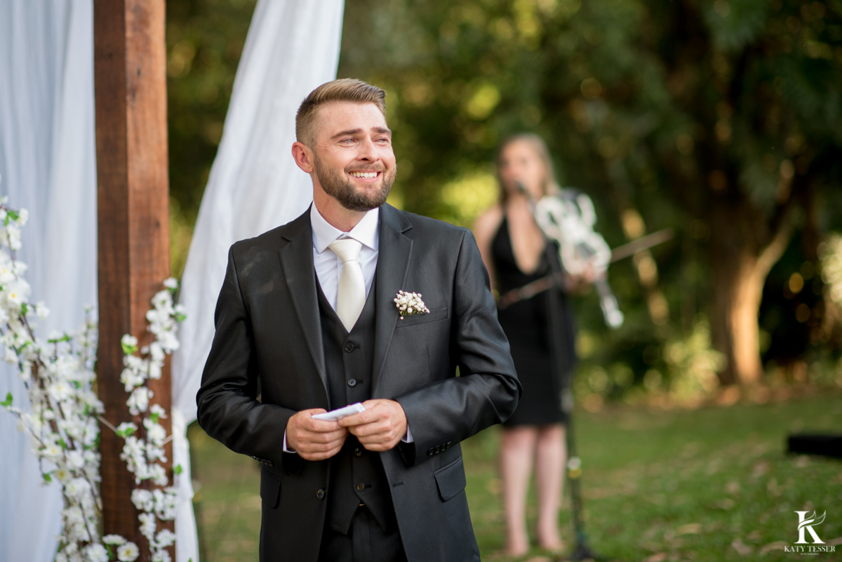 Casamento ao ar livre de dia na cabana manhare em Francisco beltrao parana de Ademir ana Paula as fotos de katy tesser fotografo o noivo emocionado na entrada da noiva