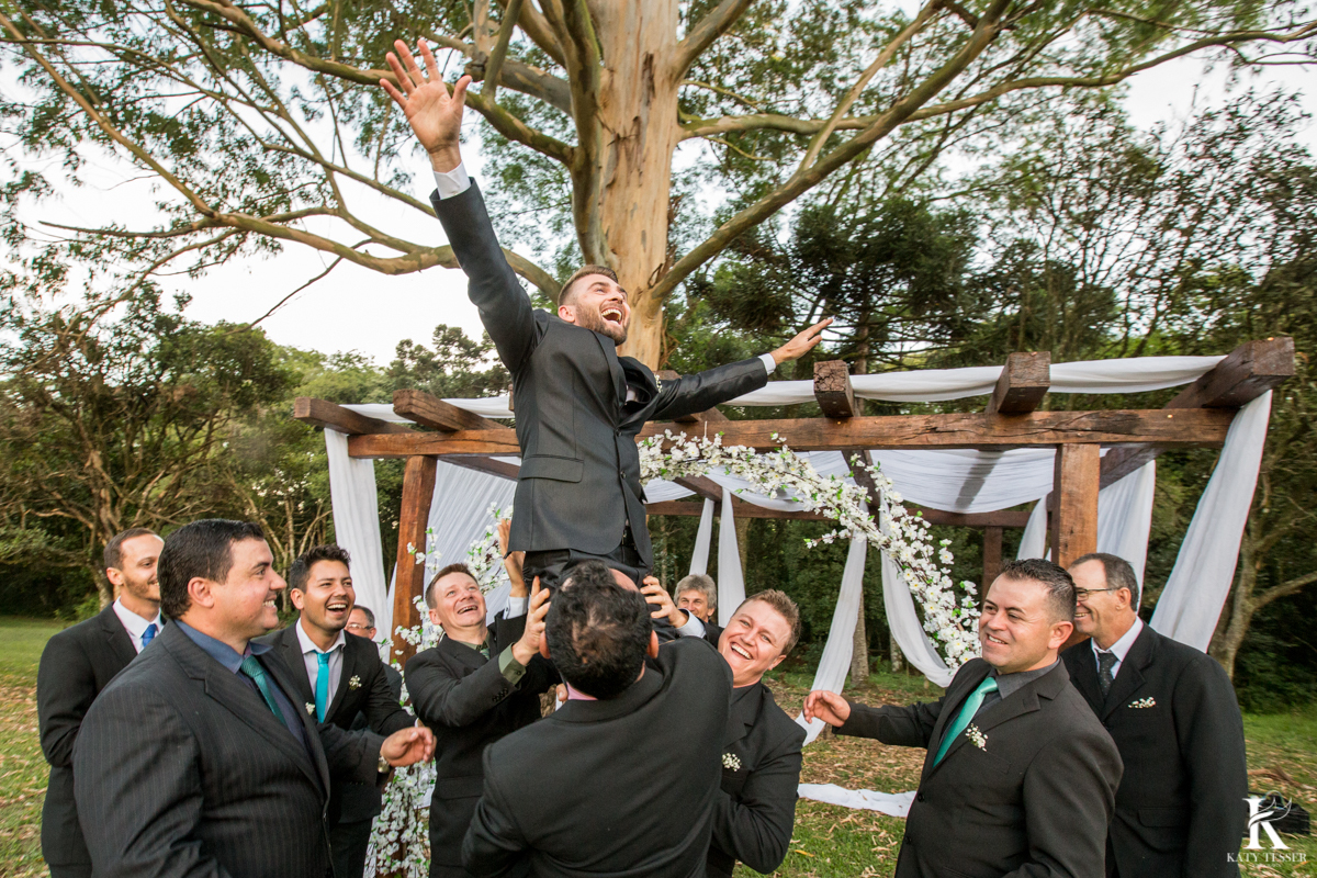 Casamento ao ar livre de dia na cabana manhare em Francisco beltrao parana de Ademir ana Paula as fotos de katy tesser fotografo os padrinhos jogando o noivo pro alto