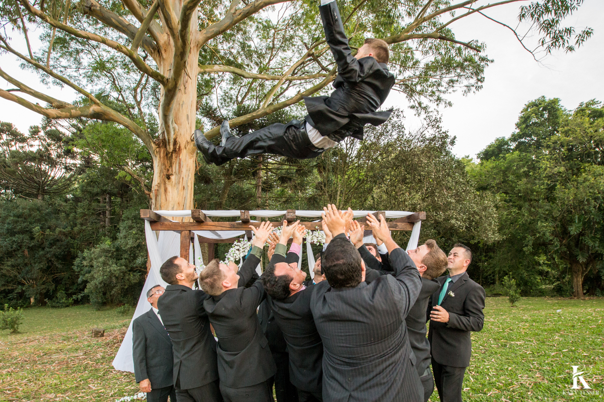 Casamento ao ar livre de dia na cabana manhare em Francisco beltrao parana de Ademir ana Paula as fotos de katy tesser fotografo os padrinhos jogando o noivo