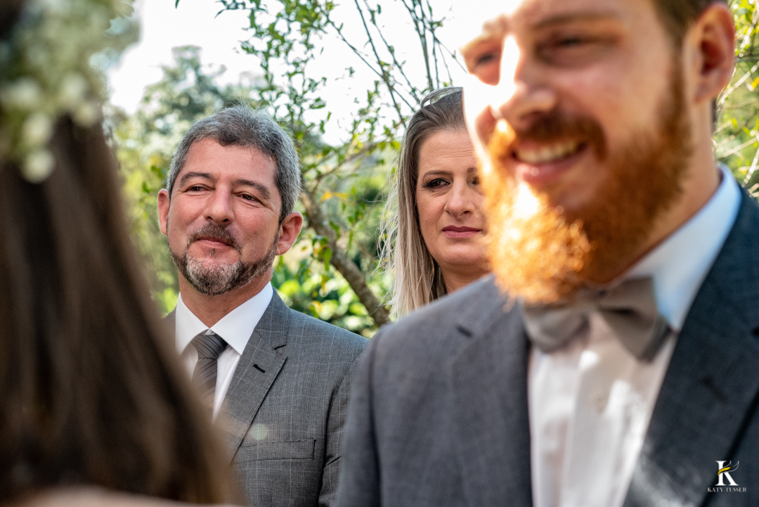 casamento intimo miniwedding de otavio de analu ao ar livre o noivo usando terno com gravata borboleta e a noiva com vestido de alca e tiara de flores na cabeça o buque de rosas amarelas com o registro fotografico por katy tesser fotografo no parana