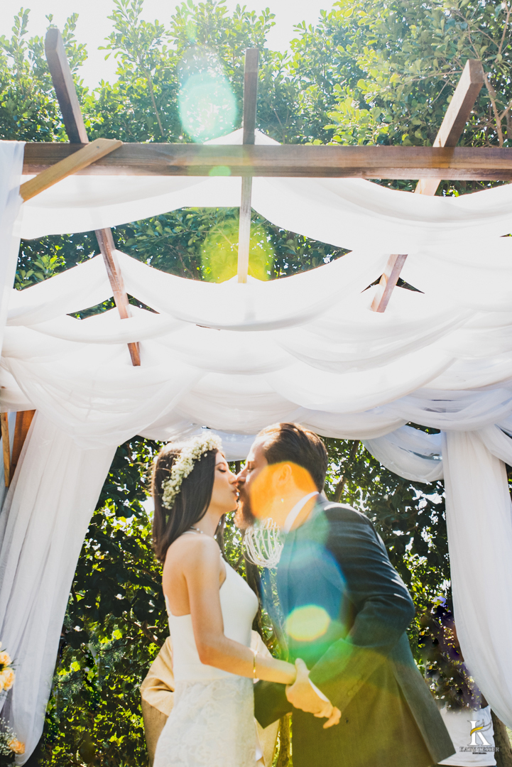 casamento intimo miniwedding de otavio de analu ao ar livre o noivo usando terno com gravata borboleta e a noiva com vestido de alca e tiara de flores na cabeça o buque de rosas amarelas com o registro fotografico por katy tesser fotografo no parana