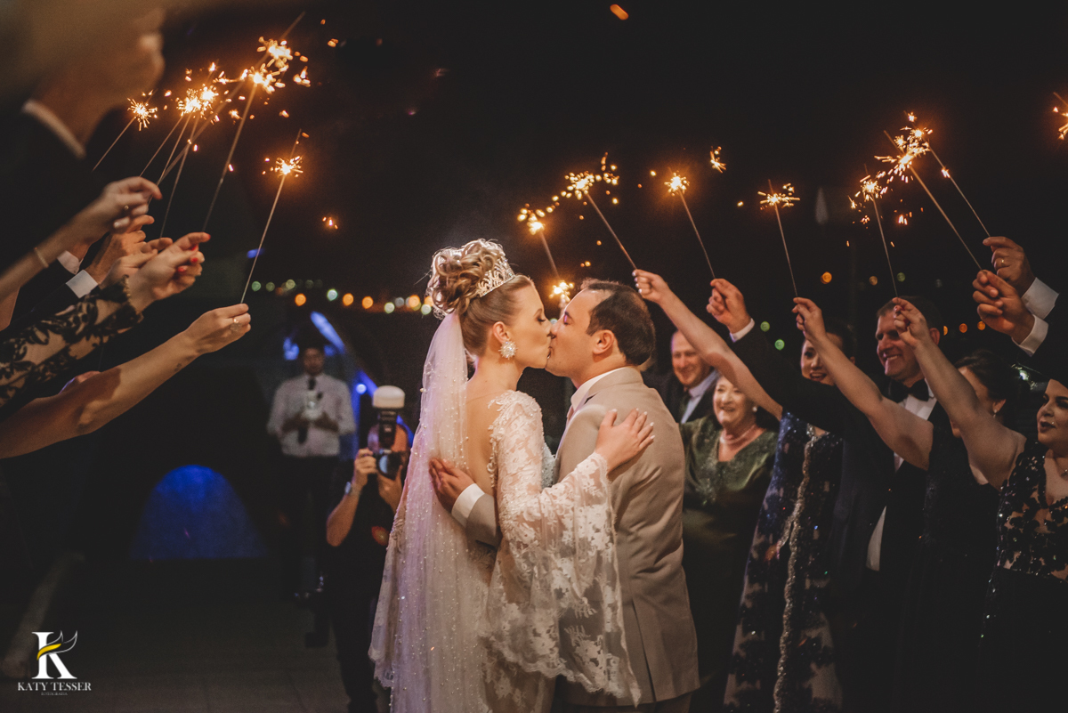 Casamento camila e Jacson laranjeiras do sul parana cerimonia tradicional Katy tesser melhor fotografo saida dos noivos com fila dos padrinhos com fogos beijo do casal