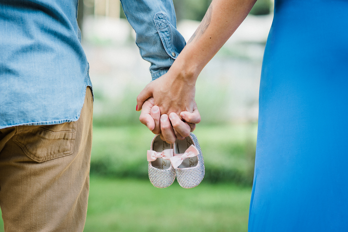 Ensaio gestante parque Burle Marx casal de mãos dadas  segurando sapatinho de bebê