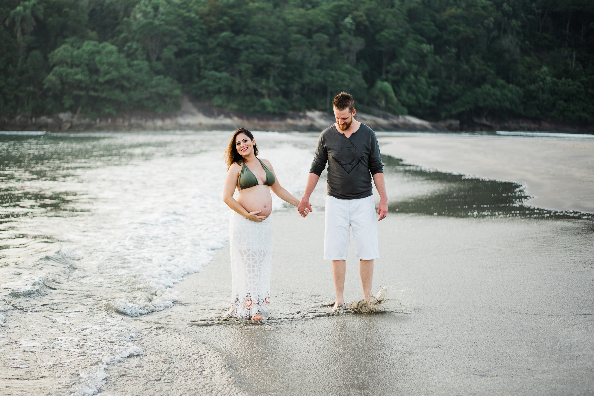 Ensaio gestante praia do Guarujá casal feliz de mãos dadas