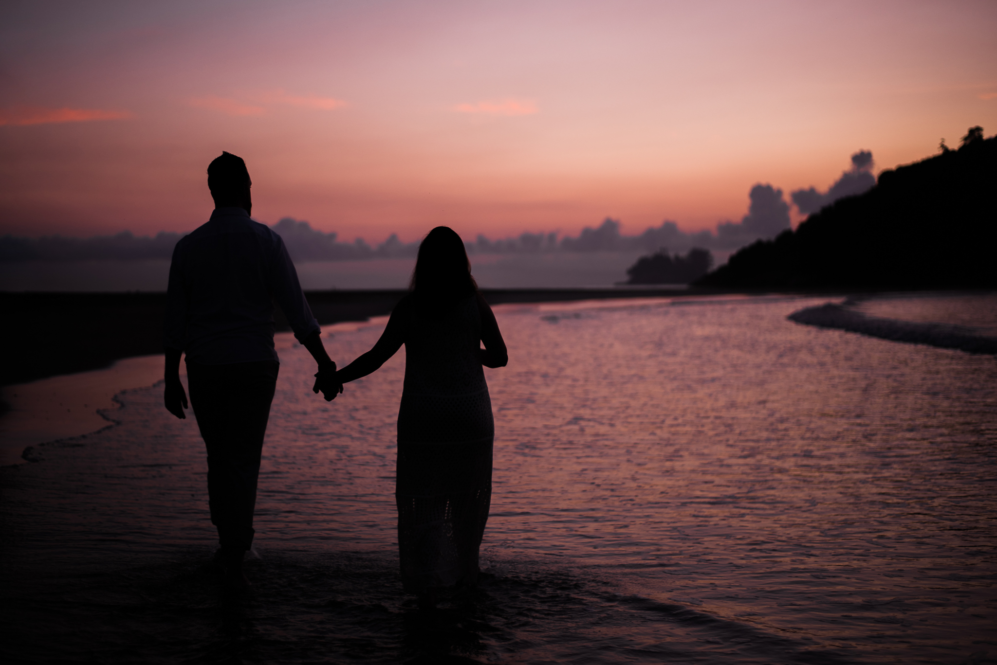Ensaio gestante praia do Guarujá casal de mãos dadas silhueta