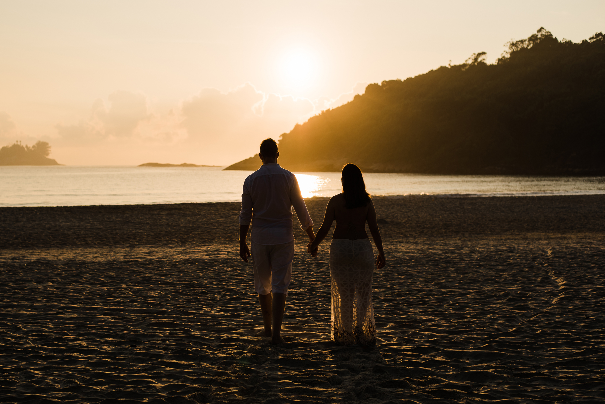 Ensaio gestante praia do Guarujá casal de mãos dadas silhueta