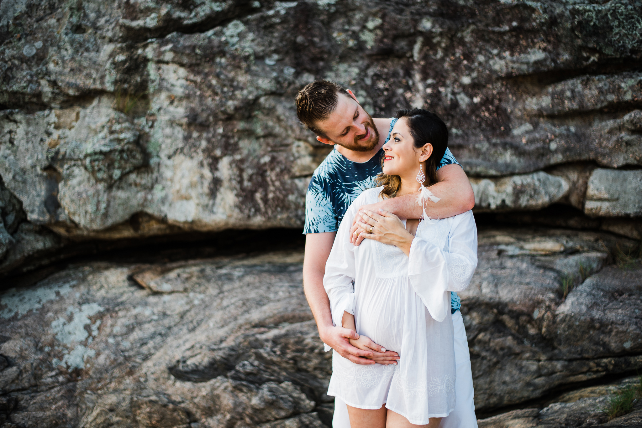 Ensaio gestante praia do Guarujá casal feliz abraçados