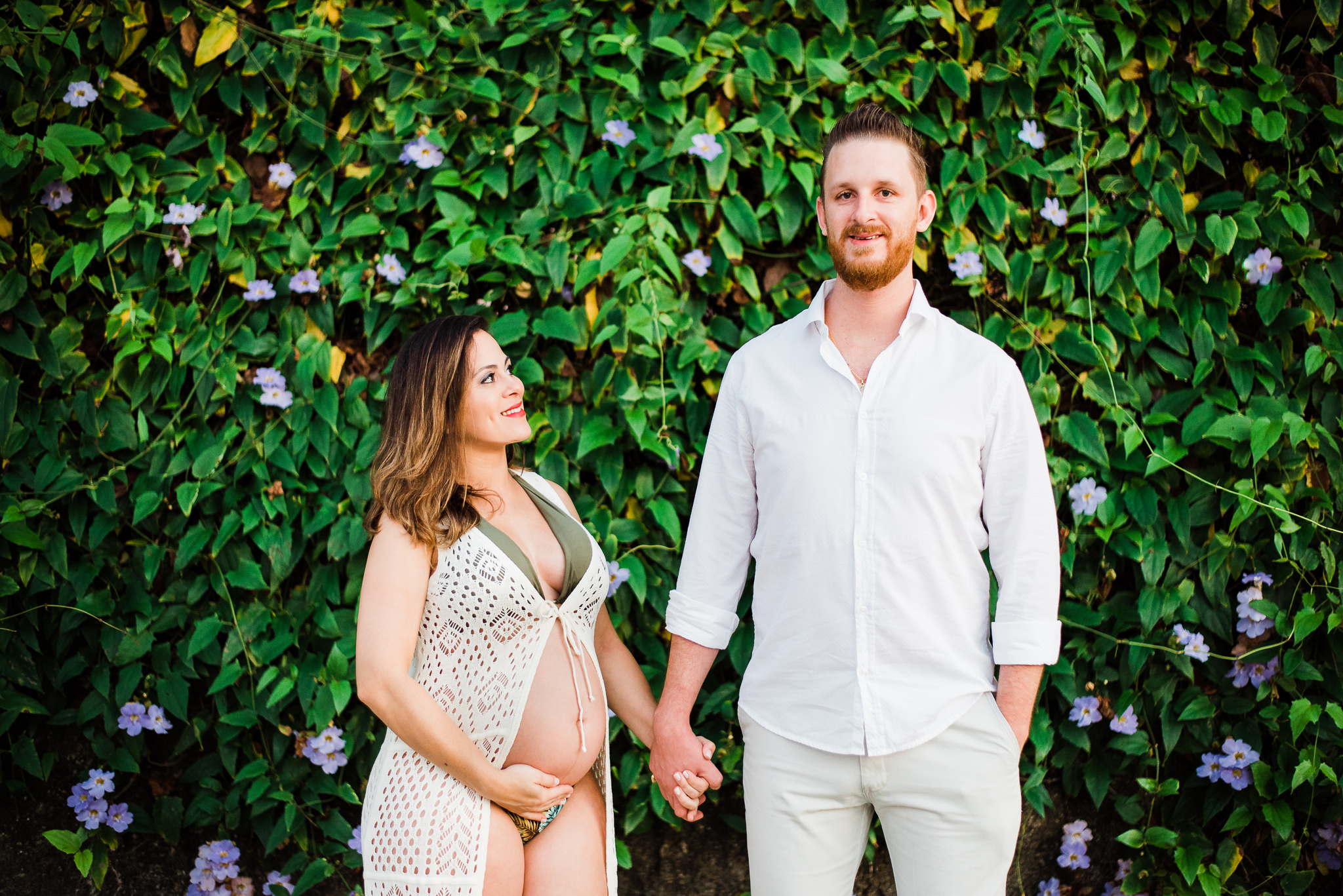 Ensaio gestante praia do Guarujá casal feliz de mãos dadas