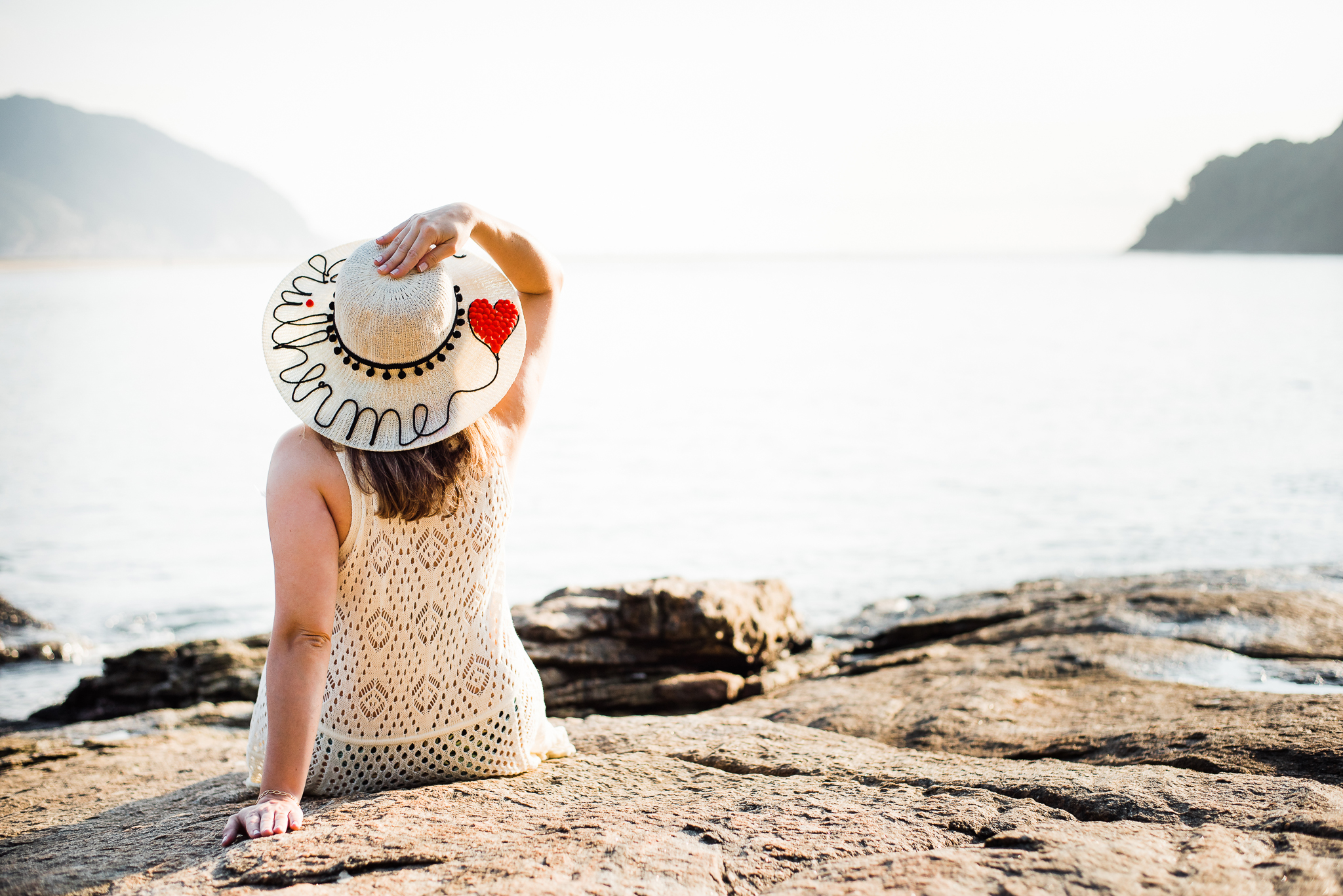 Ensaio gestante praia do Guarujá casal feliz abraçados litoral mar areia montanhas água salgada sol chapéu com o nome chapéu escrito  gestante parto maternidade gestação #gestante mamadeira amamentação barriga de gestante ensaio fotográfico book