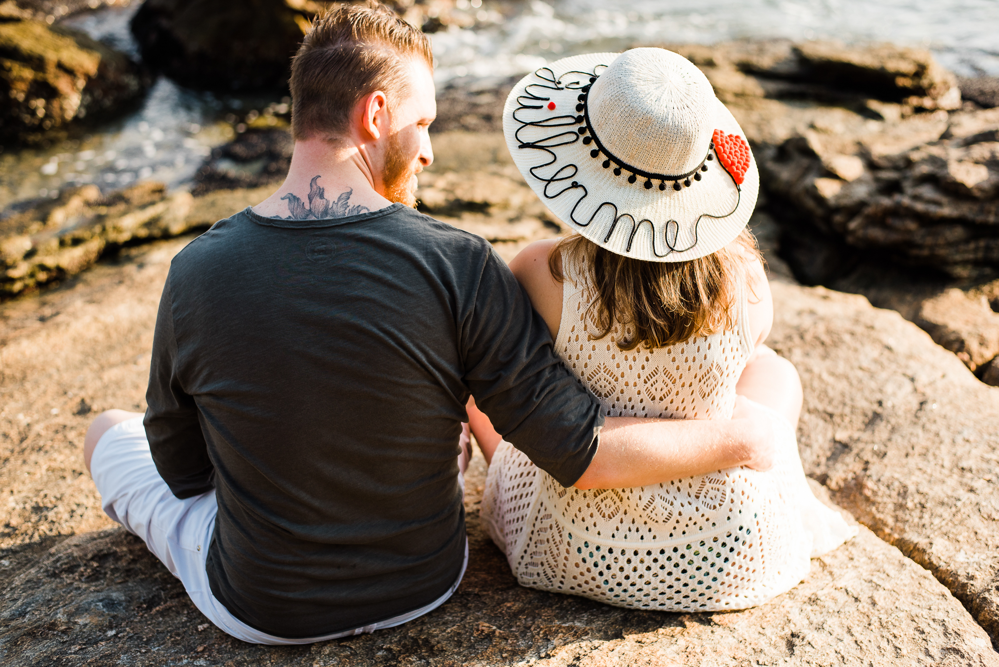 Ensaio gestante praia do Guarujá casal feliz abraçados litoral mar areia montanhas água salgada sol chapéu com o nome chapéu escrito  gestante parto maternidade gestação #gestante mamadeira amamentação barriga de gestante ensaio fotográfico book