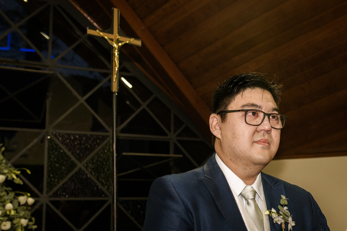 fotografia de casamento o noivo esperando no altar com a cruz