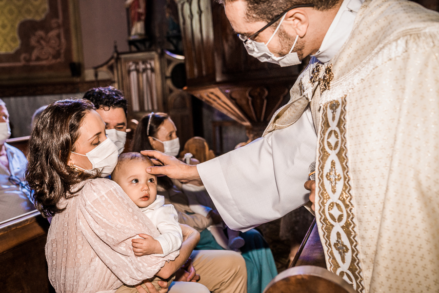 fotografia de batizado: o padre abençoando o bebê