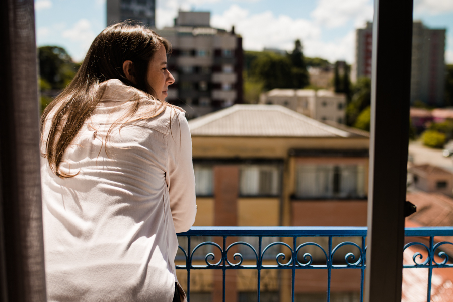 Gestante olhando a vista na sacada.