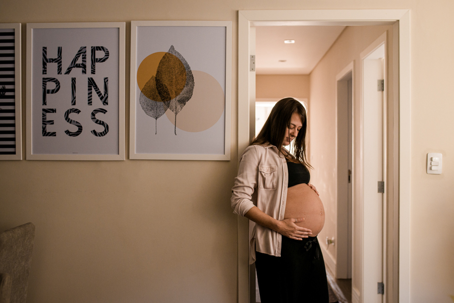 Mulher gestante na porta do corredor.