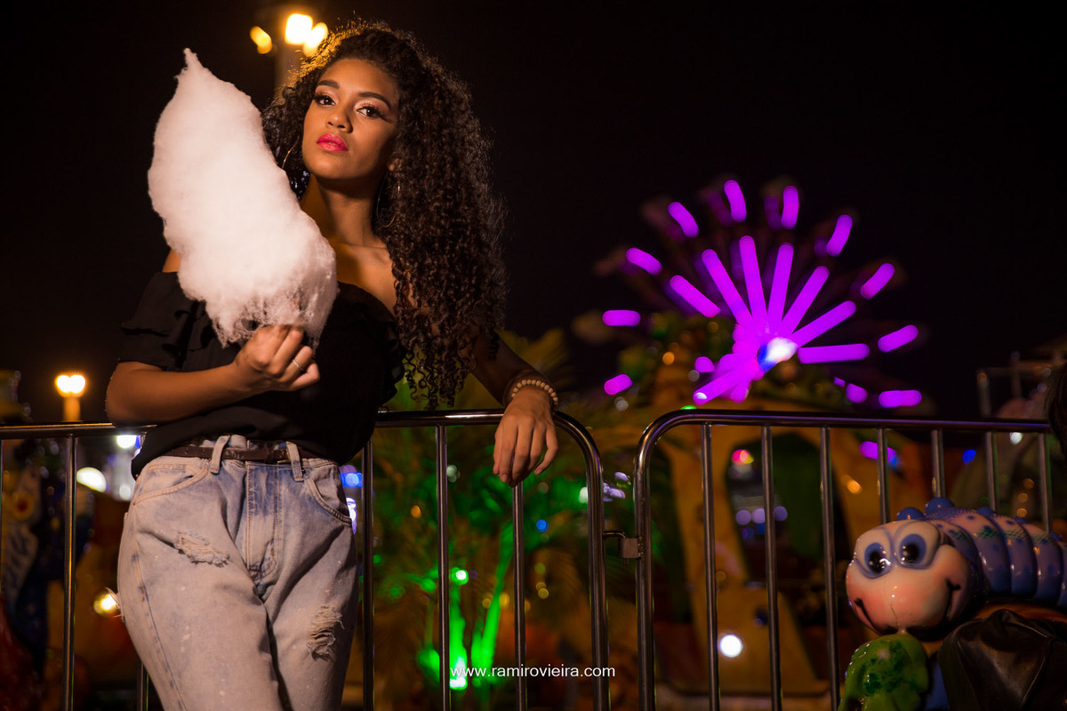 menina com algodão doce no parque de diversão