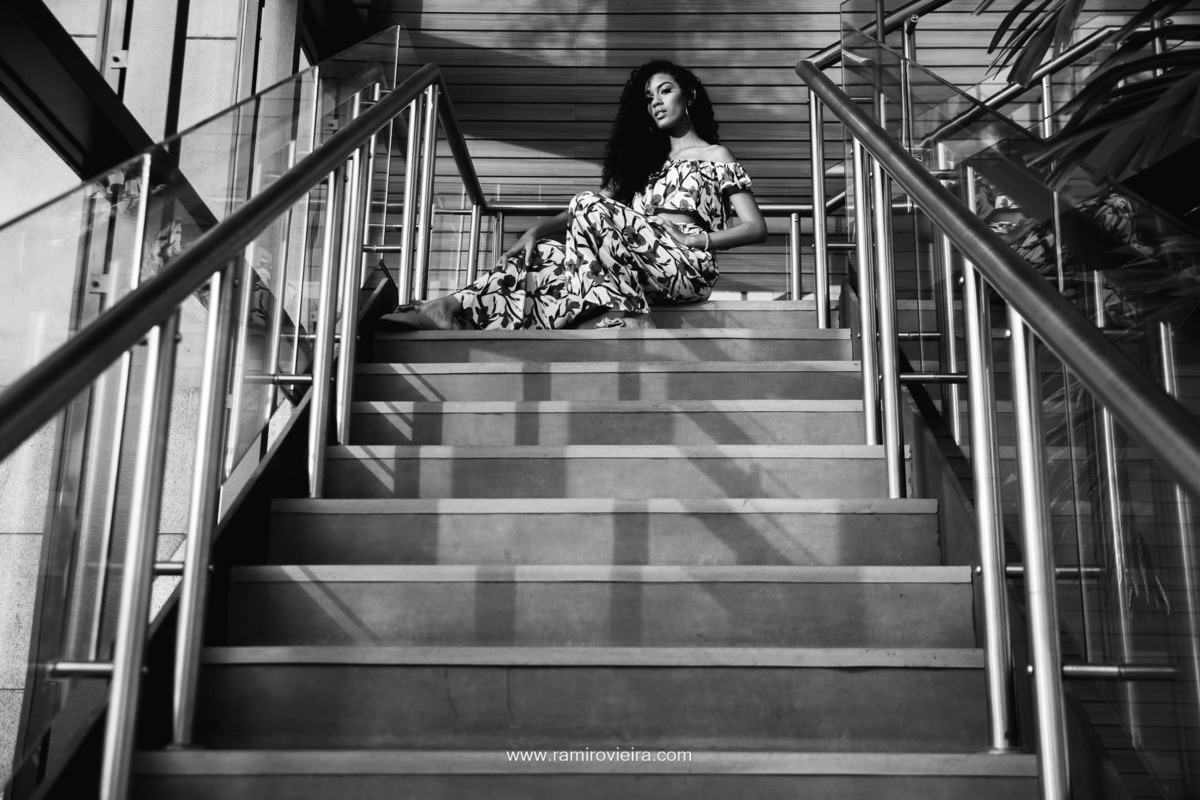 fotografia em preto e branco de uma jovem sentada na escadaria do shopping