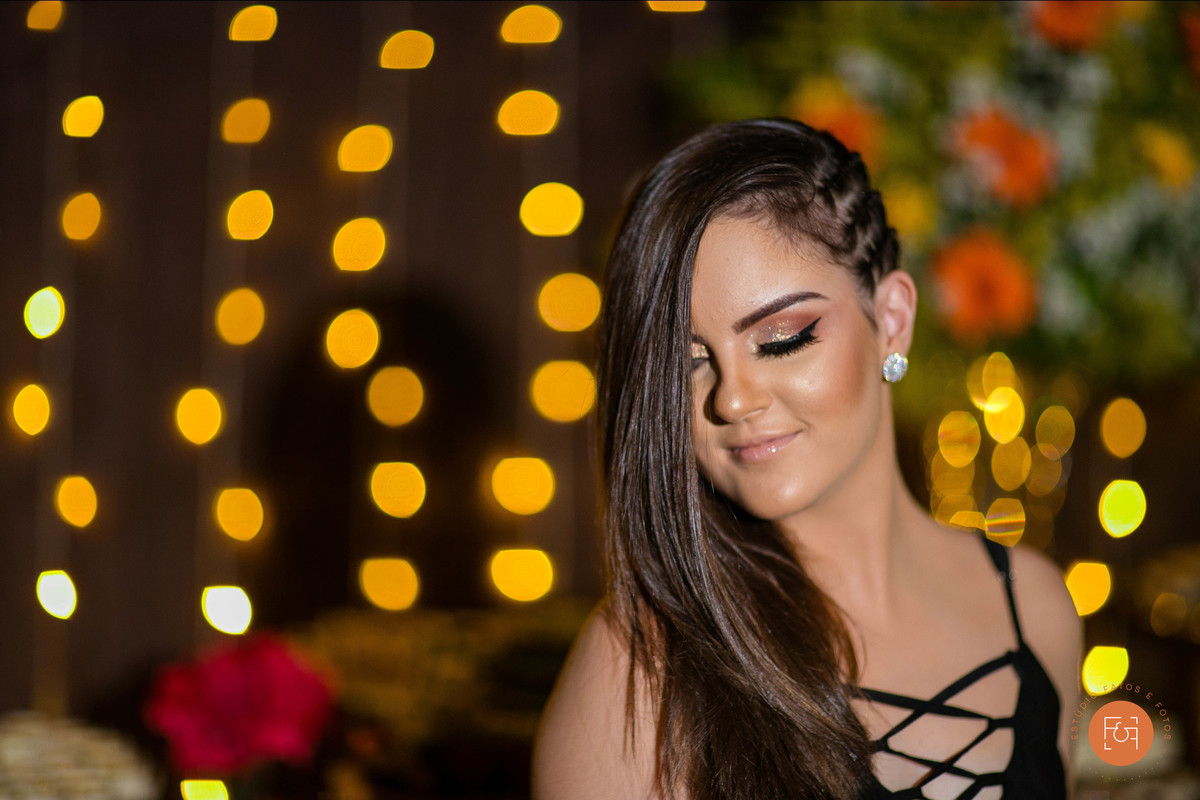 Giovana em frente a mesas do bolo