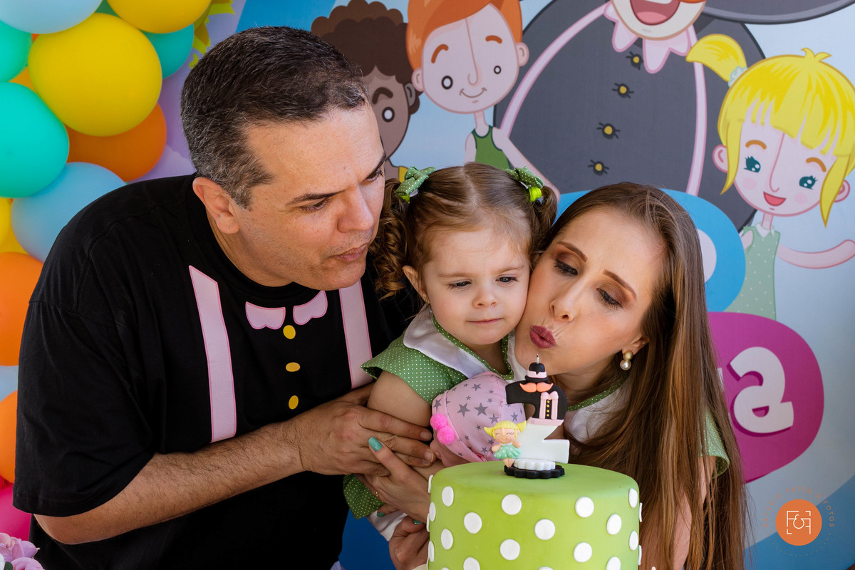 Pais e filha assoprando a velinha