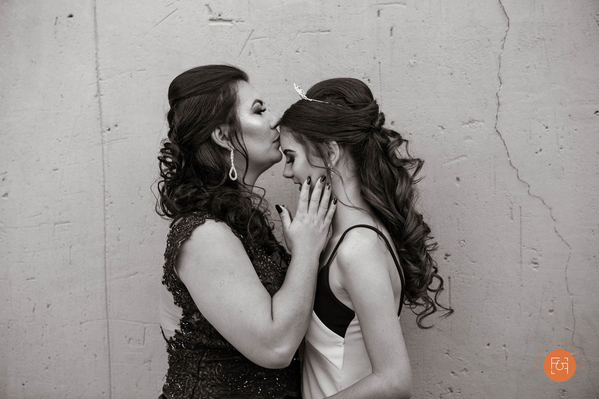 mãe beijando filha na testa