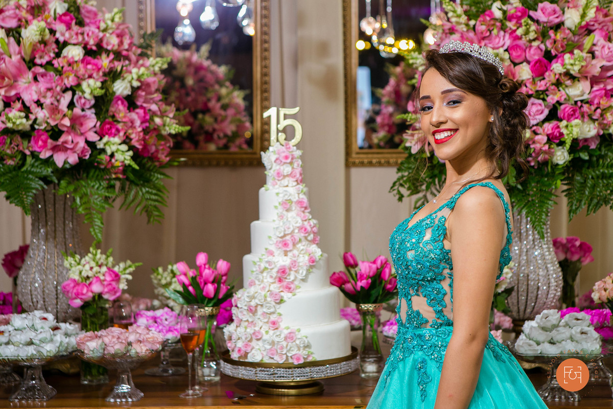 Aniversariante em frente a mesa do bolo