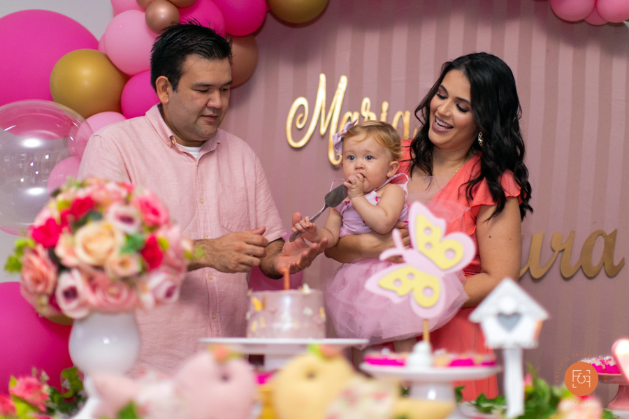 aniversariante menina cantando parabéns com os pais