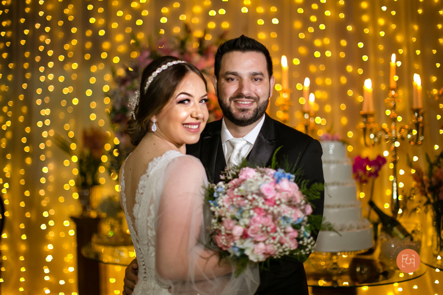 noivos na frente da mesa do bolo