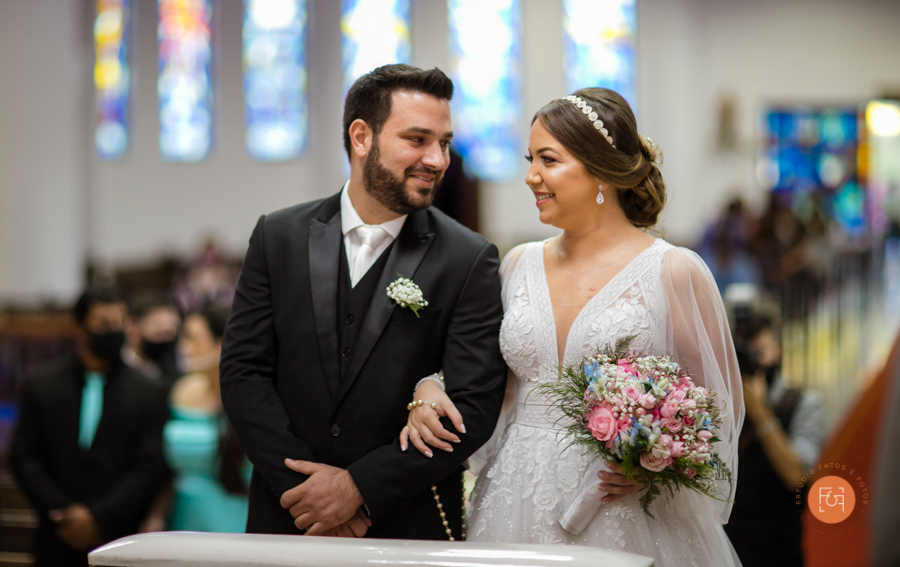 noivos sorrindo e  trocando olhares no altar