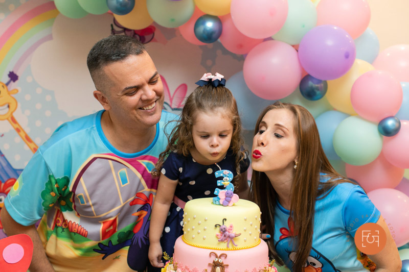 aniversariante menina cantando parabéns com os pais