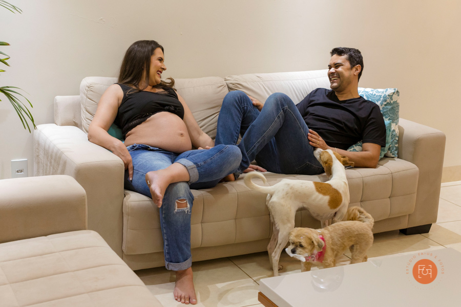 gestante com o papai sentados no sofá com os pets