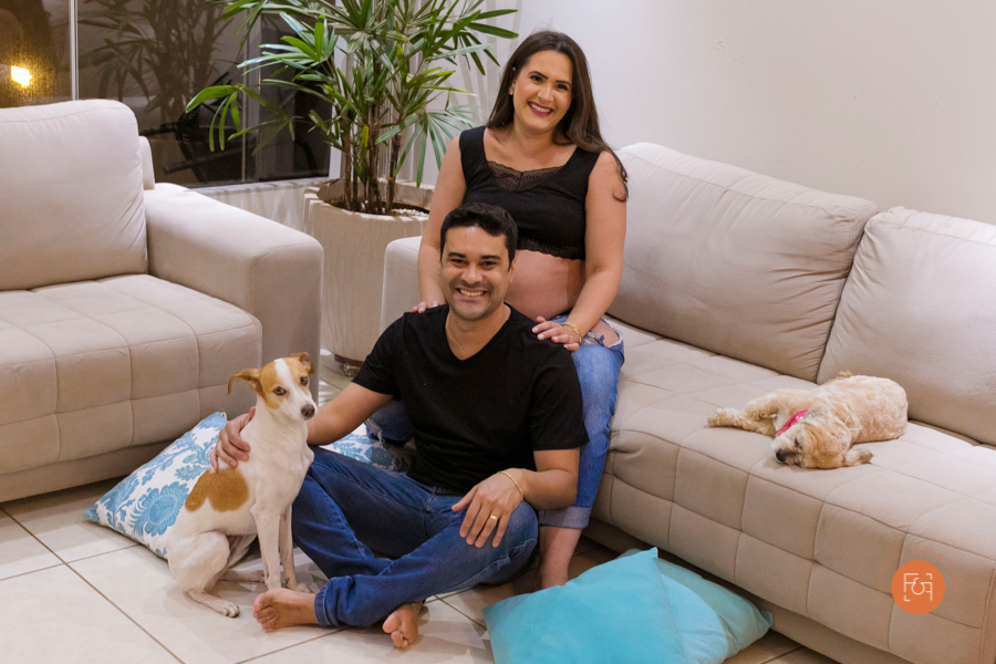 gestante com o papai sentados no sofá com os pets