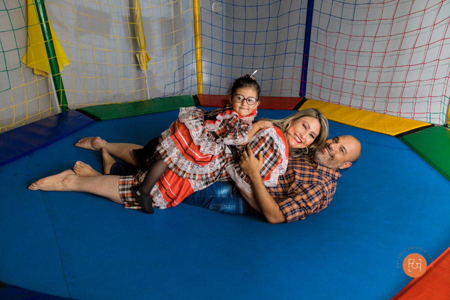 aniversariante menina brincando no pula pula com os pais
