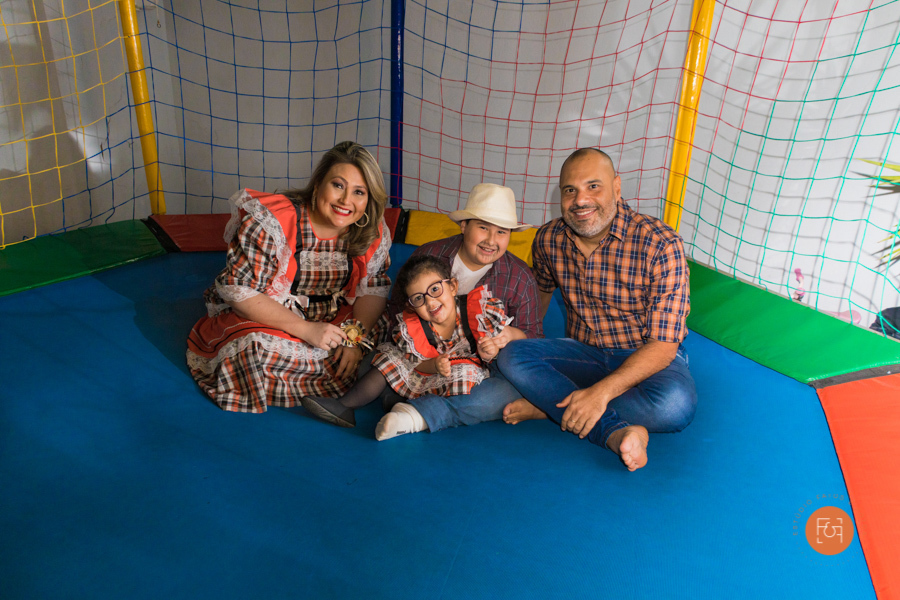 aniversariante menina brincando no pula pula com os pais e o irmão