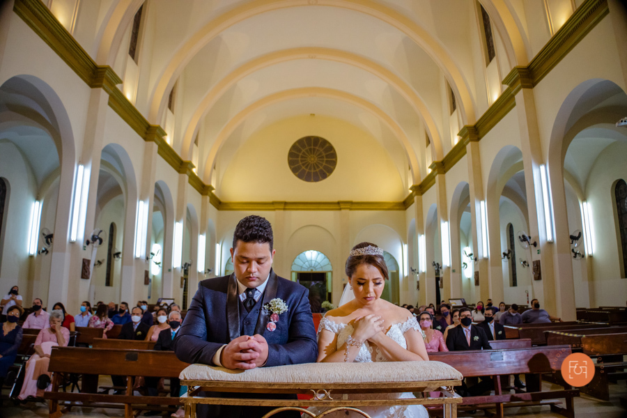 noivos ajoelhados no altar